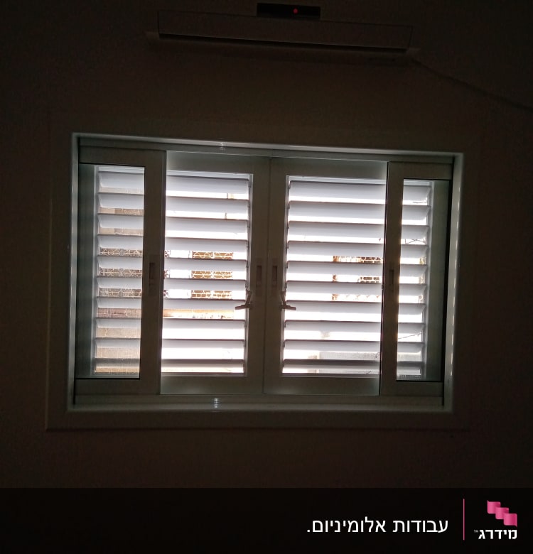 חלון עם תריסי אלומיניום סגורים